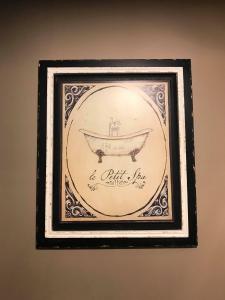 a framed picture of a bath tub on a wall at Le Relais de Chassepierre in Chassepierre