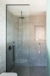um chuveiro com uma porta de vidro na casa de banho em Urban Suites em Atenas