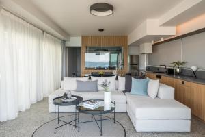 Urban Suites في أثينا: غرفة معيشة مع أريكة بيضاء وطاولة