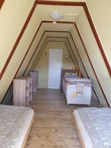 a attic room with two beds and a door at Ferienhaus am Helenesee 1 in Frankfurt/Oder