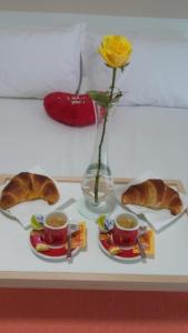 una mesa con dos tazas de café y un jarrón con una flor en Daniela B&B, en Cariati