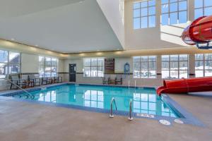 a large swimming pool with a slide in a building at Comfort Inn & Suites in Valemount