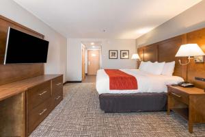 a hotel room with a bed and a flat screen tv at Comfort Inn Grove City - Columbus South in Grove City