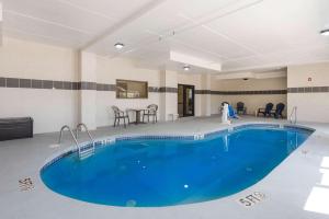 a large pool in a room with a table and chairs at Comfort Inn Grove City - Columbus South in Grove City
