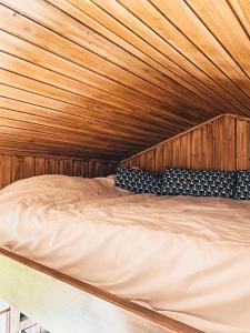 a large wooden bed in a wooden room at Joly Tiny House in Overijse