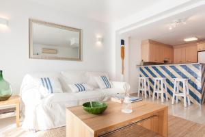a living room with a white couch and a table at Marina Boutique Duplex in Sant Antoni de Calonge