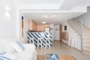 a living room with a white couch and a kitchen at Marina Boutique Duplex in Sant Antoni de Calonge