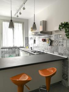 eine Küche mit zwei orangenen Stühlen an der Theke in der Unterkunft SoleMare in Levanto