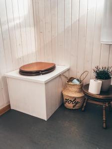 a toilet sitting on top of a white cabinet with a basket at Joly Tiny House in Overijse