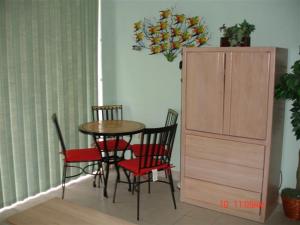 comedor con mesa, sillas y armario en Daytona Beach - Condo Ocean Front View, en Daytona Beach