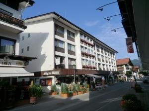 ein großes weißes Gebäude auf einer Straße mit Topfpflanzen in der Unterkunft Ferienwohnung Paulus in Oberstdorf