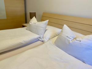 two beds with white pillows sitting next to each other at Ferienwohnungen Christine in Dornbirn