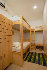 a bunk room with two bunk beds and a rug at Nap Manor Hostels in Mumbai