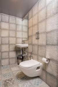 La salle de bains est pourvue de toilettes et d'un lavabo. dans l'établissement Nap Manor Hostels, à Mumbai