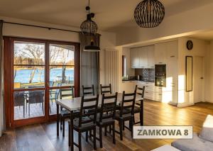 a kitchen and dining room with a table and chairs at ApartView na Mazurach "Osada Zamkowa" by Rent like home in Pasym