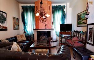 a living room with a couch and a fireplace at VILLA TASOS in Iraklitsa