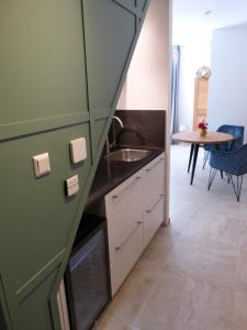 een kleine keuken met een wastafel en een tafel bij Huize Triangel - Wellness studio met sauna in Noordwolde