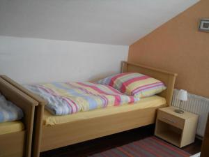 a bed with a striped comforter on it in a bedroom at Ferienwohnung Kuderer in Lunden