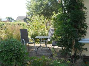 two chairs and a table in a garden at Ferienwohnung Kuderer in Lunden