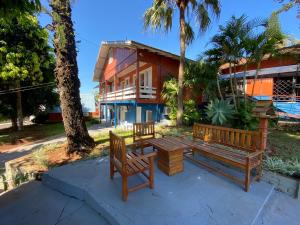 two benches and a table in front of a house at Oasis Hotel in Palmitos