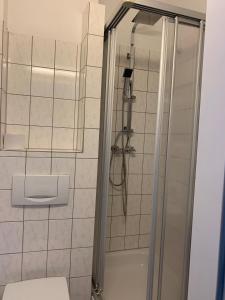 uma casa de banho com um chuveiro e um WC. em Hotel Berg em Colónia