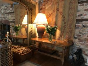 a lamp on a table in a room with a fireplace at The Tea House in Rye