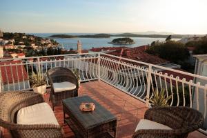 a balcony with chairs and a table with a view of the water at Tanya-Apartments and Rooms in Hvar