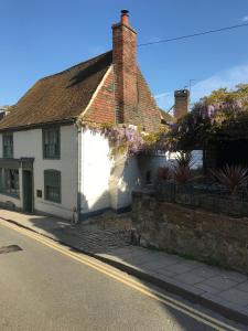 a white house with flowers on the side of it at The Tea House in Rye
