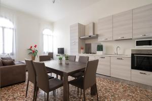 a kitchen and dining room with a wooden table and chairs at Dorsoduro Charme Apartments in Venice