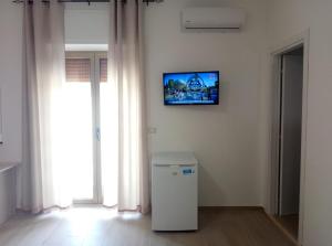ein Mülleimer in einem Zimmer mit einem Fernseher an der Wand in der Unterkunft Daniela B&B in Cariati
