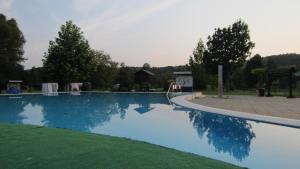 a blue swimming pool with a playground and trees at Nature House Arany in Zalaszentgrót