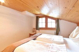 ヴェステンドルフにあるFerienwohnung Örgenhofの木製の天井のベッドルーム1室(大型ベッド1台付)