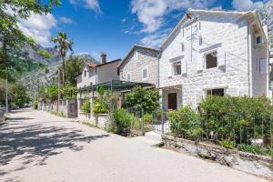 a white building with a fence next to a street at Old Stone Villa Lalosevic in Kotor