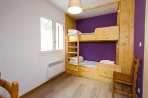 Habitación con litera, paredes de color púrpura y ventana. en Les chalets de Pré Clos en Vercors en Saint-Andéol