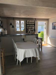 Rødhus Gl. Skole B&B في Pandrup: غرفة طعام مع طاولة بيضاء وكراسي