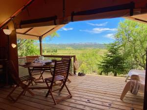 a table and chairs on a deck with a view at Lodge en Pays Cathare in Tuchan
