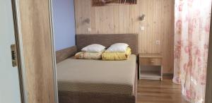 a bedroom with a bed with two pillows on it at Vieno aukšto kotedžas in Šventoji