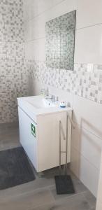 a white bathroom with a sink and a mirror at Casa o Cantinho in Mourão +17 photos