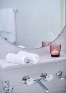 a bathroom with a towel and a candle on a shelf at CIP Hôtel in Tramelan