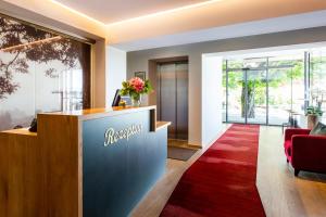 a lobby with a reception desk and a red rug at Landhotel Gottinger in Waldkirchen