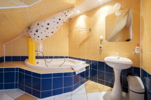 a bathroom with a tub and a sink and a toilet at Willa Krystyna in Krynica Zdrój