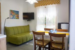 sala de estar con sofá verde y mesa en La casetta di Kamma & Niels a Montenotte, en Montenotte Inferiore