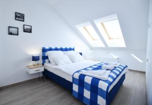 a bedroom with a blue and white bed with a window at Sunset Resort, Nadmorska 106 in Grzybowo