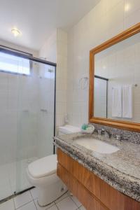 a bathroom with a sink and a toilet and a mirror at Tulip Inn Fortaleza in Fortaleza