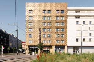 a tall brick building on a city street at Hotel Schani Wien in Vienna