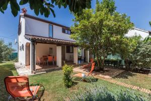 une maison avec des chaises orange dans la cour dans l'établissement Holiday house Pineta - Fazana, sea view & mini wellness, à Fažana
