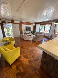 a living room with wooden floors and yellow chairs at Oasis Hotel in Palmitos