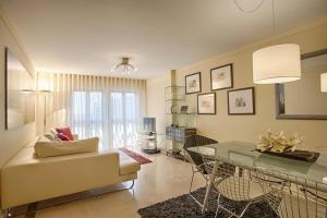 a living room with a couch and a glass table at Green Executive Apartment in the heart of Lisbon in Lisbon