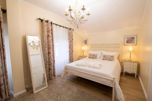 a bedroom with a white bed and a chandelier at Sete Cidades Quinta Da Queiró in Sete Cidades