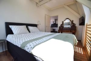 sypialnia z dużym łóżkiem i lustrem w obiekcie Bed & Breakfast De Barrels w mieście Groningen